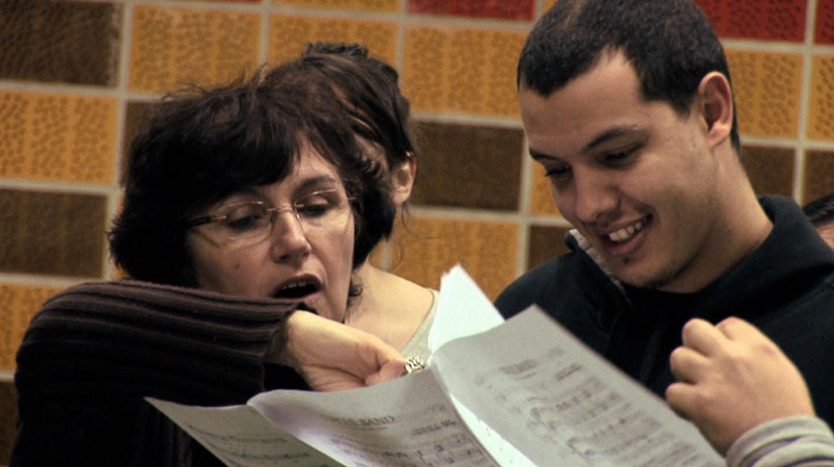 Marie-Laure Teissèdre (directrice artistique et musicale du Choeur Emelthée) guide Riyad Fghani, chorégraphe de la Cie Pockemon Crew qui s'essaye au chant.