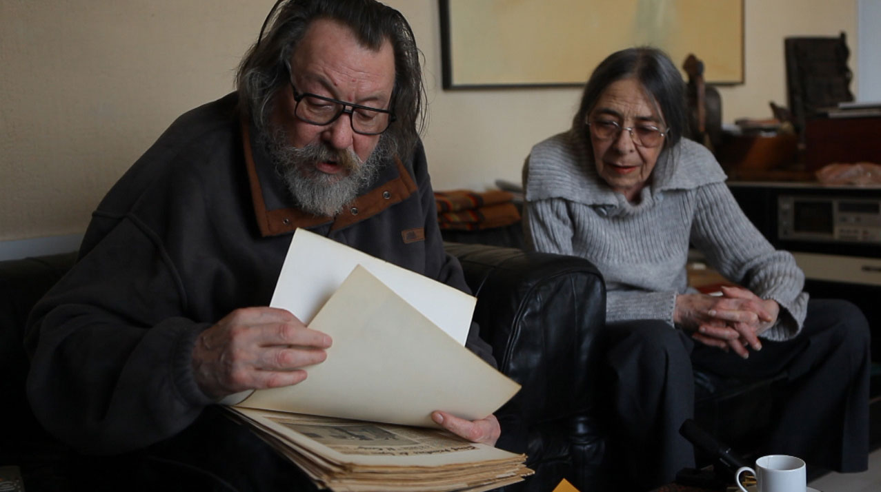 Jean et Michelle Janoir lisent de vieilles coupures de presse.